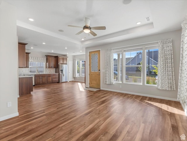 6067 W Whisle Stop Rd S, South Jordan, UT 84009 - unfurnished living room featuring a ceiling fan, a raised ceiling, dark wood finished floors, and recessed lighting