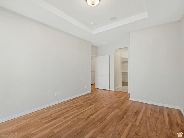 6067 W Whisle Stop Rd S, South Jordan, UT 84009 - unfurnished bedroom featuring light wood-style flooring, a raised ceiling, a walk in closet, and a closet