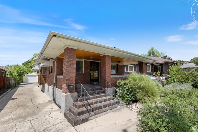 1143 E 1300 S, Salt Lake City, UT 84105 - view of front of property featuring brick siding, a porch, an outdoor structure, and a garage