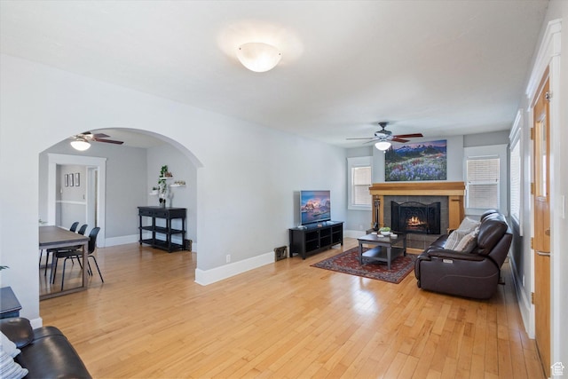 1143 E 1300 S, Salt Lake City, UT 84105 - living area with ceiling fan, arched walkways, light wood-style flooring, and a lit fireplace