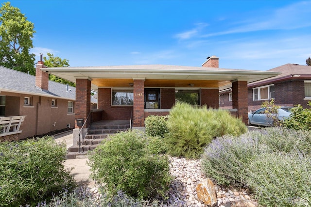 1143 E 1300 S, Salt Lake City, UT 84105 - view of front facade with covered porch, brick siding, and a chimney