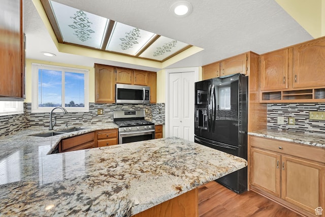 3972 S 4450 W, West Haven, UT 84401 - kitchen featuring stainless steel appliances, tasteful backsplash, light stone countertops, light wood-style floors, and a peninsula