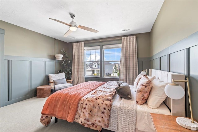 10262 N Yorkshire Cir, Highland, UT 84003 - bedroom featuring a decorative wall, wainscoting, a ceiling fan, and carpet flooring