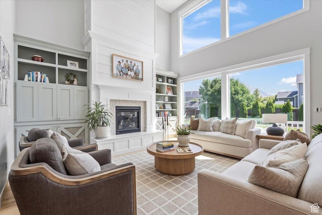 10262 N Yorkshire Cir, Highland, UT 84003 - living area featuring a towering ceiling, a glass covered fireplace, and built in features