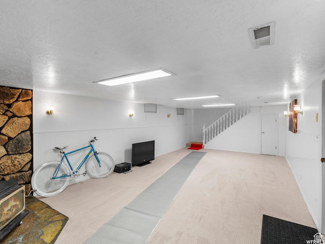 1034 E 1st St S, Ogden, UT 84404 - finished below grade area with a wood stove, a textured ceiling, carpet flooring, and stairs