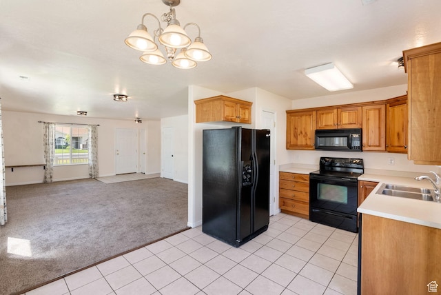 145 Teal Loop, Logan, UT 84321 - kitchen featuring black appliances, light colored carpet, light countertops, open floor plan, and a chandelier