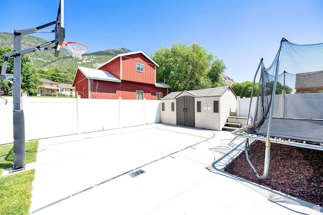 1788 N 925 E, North Ogden, UT 84414 - fenced backyard featuring a trampoline, a storage unit, and a patio area