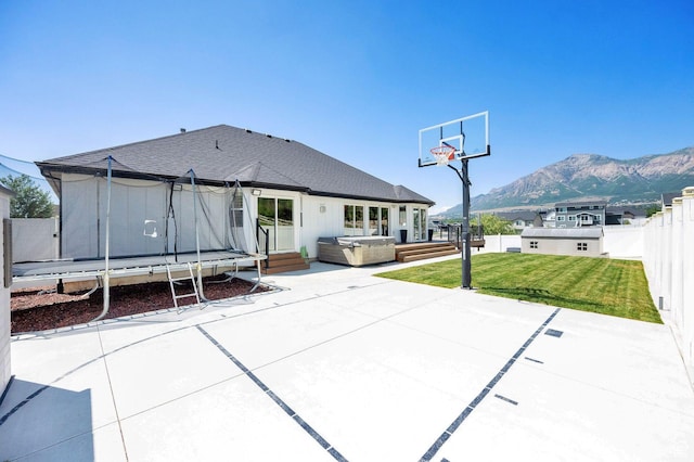 1788 N 925 E, North Ogden, UT 84414 - rear view of property with a hot tub, a patio, a trampoline, a mountain view, and roof with shingles