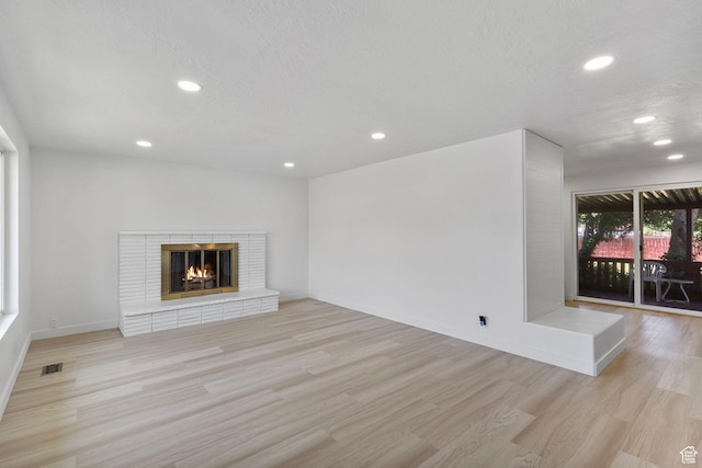 5600 S Ralph Dr, Taylorsville, UT 84129 - unfurnished living room with recessed lighting, light wood-type flooring, and a fireplace