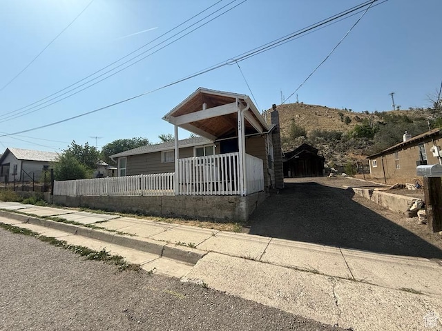 365 Hill St, Helper, UT 84526 - view of front of house featuring a fenced front yard, a porch, asphalt driveway, and a chimney