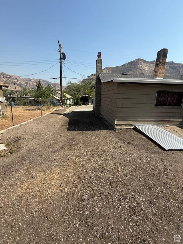 365 Hill St, Helper, UT 84526 - view of side of property with a chimney, driveway, and a mountain view