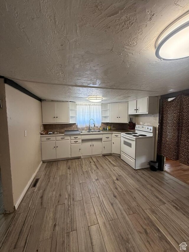 365 Hill St, Helper, UT 84526 - kitchen with white range with electric cooktop, wood finished floors, white cabinetry, a textured ceiling, and dark countertops