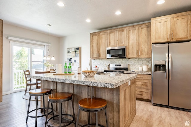 728 W 12260 S, Draper, UT 84020 - kitchen featuring stainless steel appliances, light wood-style floors, a kitchen island, tasteful backsplash, and recessed lighting