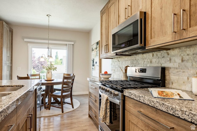 728 W 12260 S, Draper, UT 84020 - kitchen featuring appliances with stainless steel finishes, tasteful backsplash, light wood-type flooring, light stone countertops, and decorative light fixtures