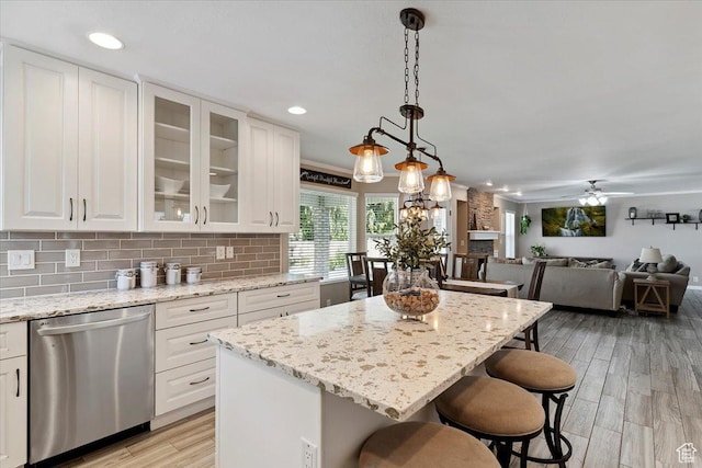 7258 S Mel Helen Way, West Jordan, UT 84084 - kitchen featuring dishwasher, a kitchen breakfast bar, white cabinets, light wood-style flooring, and backsplash