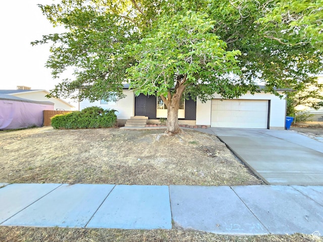 3797 S Armoridge Dr, Magna, UT 84044 - view of property hidden behind natural elements featuring an attached garage, driveway, and brick siding