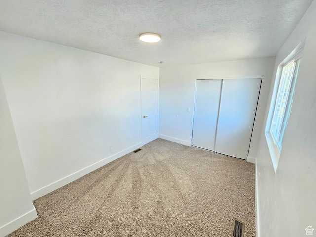 3797 S Armoridge Dr, Magna, UT 84044 - unfurnished bedroom with light colored carpet, a textured ceiling, and a closet