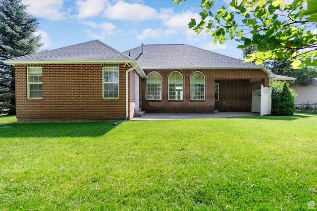 831 N Brookside Dr, Preston, ID 83263 - rear view of property with a shingled roof, a patio area, a yard, and brick siding