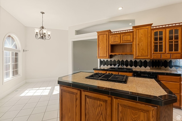 831 N Brookside Dr, Preston, ID 83263 - kitchen featuring stovetop with downdraft, backsplash, a chandelier, a center island, and light tile patterned flooring