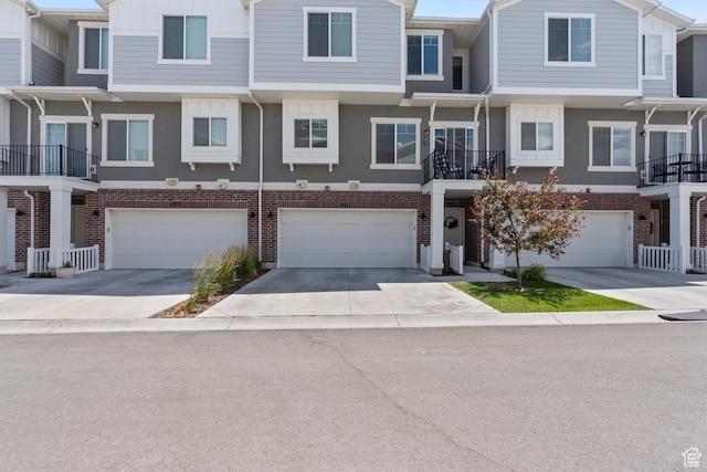 4211 W Camp Floyd Ct, Riverton, UT 84096 - view of property featuring a garage, driveway, brick siding, and stucco siding