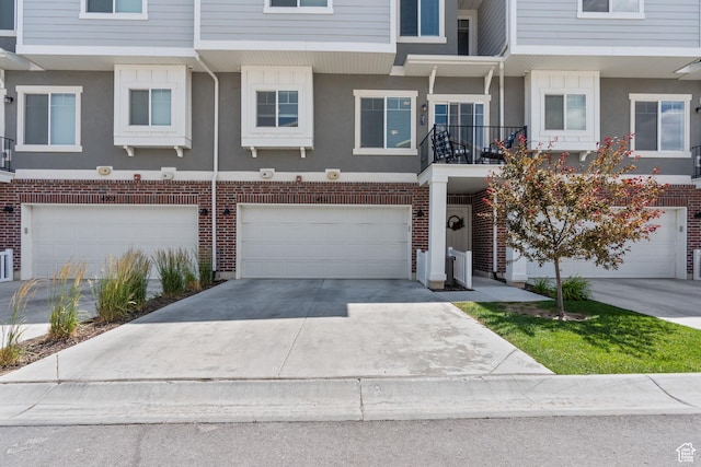 4211 W Camp Floyd Ct, Riverton, UT 84096 - townhome / multi-family property with a garage, concrete driveway, stucco siding, and brick siding
