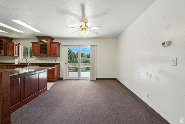 434 River Heights Blvd, River Heights, UT 84321 - kitchen featuring dark countertops, ceiling fan, glass insert cabinets, carpet flooring, and dark brown cabinets