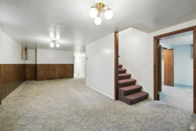 434 River Heights Blvd, River Heights, UT 84321 - finished basement with carpet, a textured ceiling, stairway, a wainscoted wall, and wooden walls