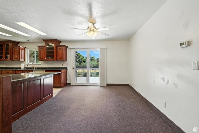 434 River Heights Blvd, River Heights, UT 84321 - kitchen with dark countertops, glass insert cabinets, ceiling fan, dark brown cabinets, and a textured ceiling