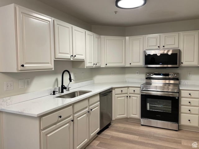 8176 N Cedar Springs Rd Unit V3, Eagle Mountain, UT 84005 - kitchen with appliances with stainless steel finishes, light countertops, light wood-type flooring, and white cabinetry