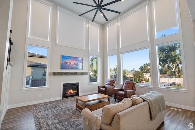 1401 W 1930 N, Pleasant Grove, UT 84062 - living area featuring wood finished floors, a glass covered fireplace, a ceiling fan, and a towering ceiling
