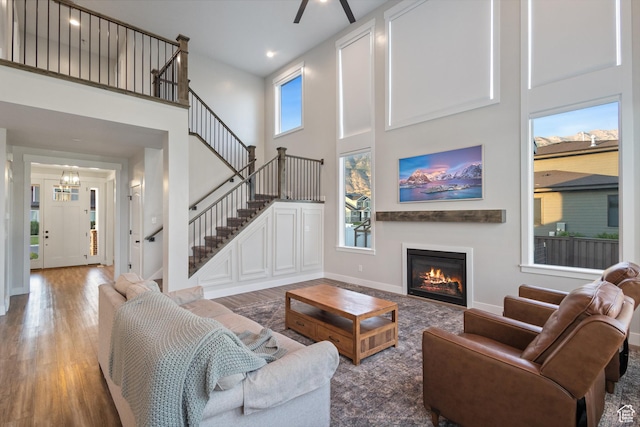 1401 W 1930 N, Pleasant Grove, UT 84062 - living area with wood finished floors, a towering ceiling, a glass covered fireplace, stairs, and a ceiling fan