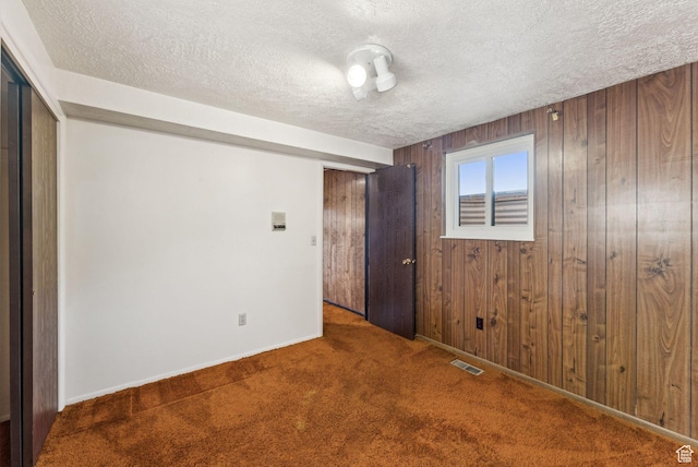 3327 S Crestwood Dr, Salt Lake City, UT 84109 - carpeted spare room featuring a textured ceiling and wood walls