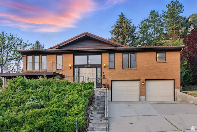 3327 S Crestwood Dr, Salt Lake City, UT 84109 - view of front of house with a garage, driveway, brick siding, and stairway