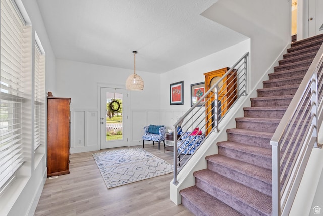 11571 S Skyward Rd W, South Jordan, UT 84009 - foyer with stairs, light wood-style floors, a wainscoted wall, and a decorative wall