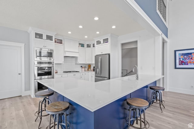11571 S Skyward Rd W, South Jordan, UT 84009 - kitchen with appliances with stainless steel finishes, light wood finished floors, recessed lighting, white cabinets, and decorative backsplash