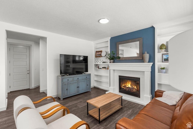 22 W Orchard Ln Unit 202, Bountiful, UT 84010 - living room featuring built in features, a glass covered fireplace, dark wood-style flooring, and a textured ceiling