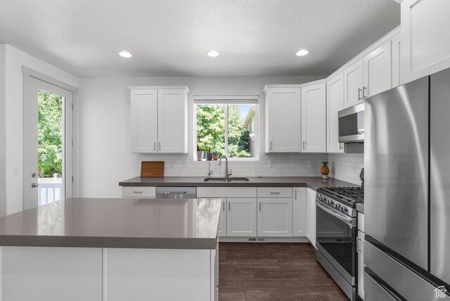 22 W Orchard Ln Unit 202, Bountiful, UT 84010 - kitchen with appliances with stainless steel finishes, dark countertops, dark wood-style floors, decorative backsplash, and recessed lighting