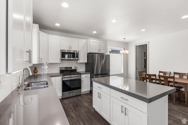 22 W Orchard Ln Unit 202, Bountiful, UT 84010 - kitchen featuring appliances with stainless steel finishes, dark wood-style flooring, backsplash, a chandelier, and dark countertops