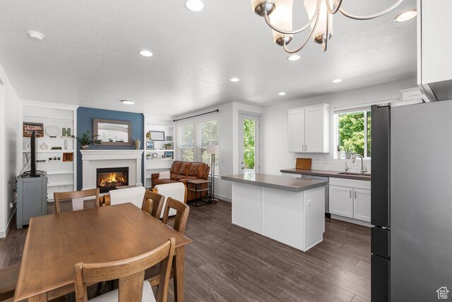 22 W Orchard Ln Unit 202, Bountiful, UT 84010 - dining space featuring a warm lit fireplace, recessed lighting, dark wood-type flooring, built in shelves, and a chandelier