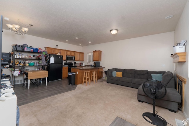 392 E 700 S Unit H, Vernal, UT 84078 - living area with a chandelier, light colored carpet, recessed lighting, a textured ceiling, and light wood-style floors