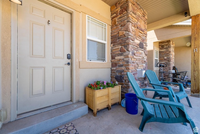 392 E 700 S Unit H, Vernal, UT 84078 - view of exterior entry featuring stucco siding, covered porch, and stone siding