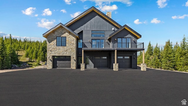 926 E Autumn Dr, Brian Head, UT 84719 - view of front of property with stone siding, a balcony, a chimney, and a garage