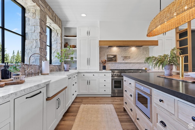 926 E Autumn Dr, Brian Head, UT 84719 - kitchen with stainless steel appliances, open shelves, tasteful backsplash, white cabinets, and light wood-type flooring