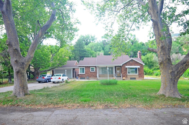 1160 E 12th St S, Ogden, UT 84404 - ranch-style home featuring a garage, brick siding, driveway, a chimney, and a front yard