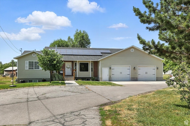 85 S 300 W, Smithfield, UT 84335 - view of front of house featuring a front yard, an attached garage, solar panels, asphalt driveway, and roof with shingles