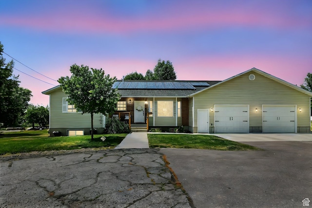 85 S 300 W, Smithfield, UT 84335 - ranch-style house with concrete driveway, roof mounted solar panels, a garage, a yard, and covered porch