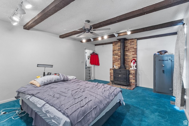 150 S 100 W, Tooele, UT 84074 - carpeted bedroom featuring beamed ceiling, a textured ceiling, a wood stove, track lighting, and ceiling fan