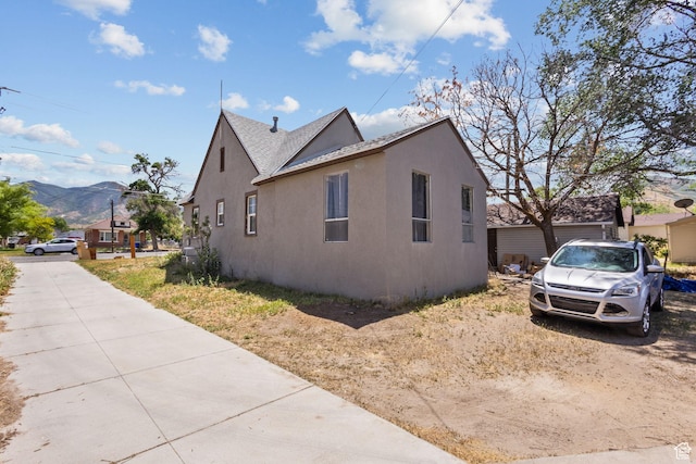 150 S 100 W, Tooele, UT 84074 - view of home's exterior featuring stucco siding, a mountain view, and a shingled roof
