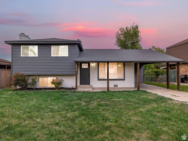 4912 W Seneca Rd S, West Valley City, UT 84120 - split level home featuring brick siding, a carport, concrete driveway, a chimney, and roof with shingles