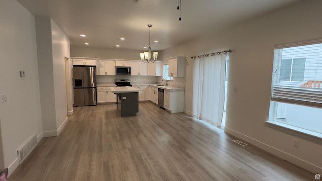 427 E 340 N, Vineyard, UT 84059 - kitchen with stainless steel appliances, a chandelier, healthy amount of natural light, wood finished floors, and recessed lighting